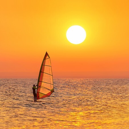 Windsurfer silhouette at sea sunset